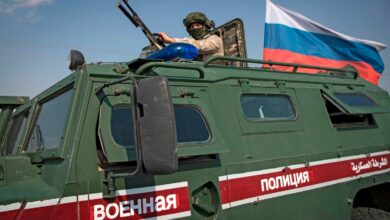 A soldier rides atop a Russian military vehicle near the Syrian northeastern city of Qamishli on Oct. 26, 2019.