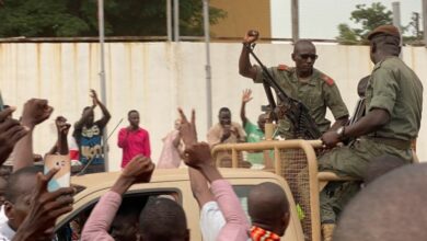 Malian soldiers surrounded by villagers.