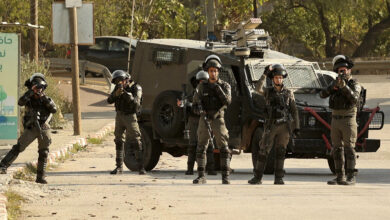 Members of the Israeli border guards block the entrance to the village of Al-Lubban Al-Sharqiah, south of Nablus, during a demonstration by settlers at the entrance to the village