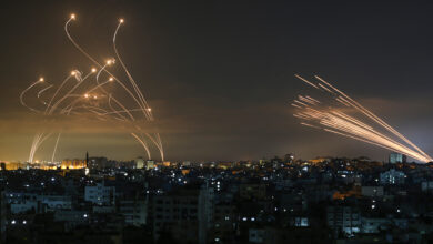 The Israeli Iron Dome missile defense system, left, intercepts rockets fired from Gaza Strip
