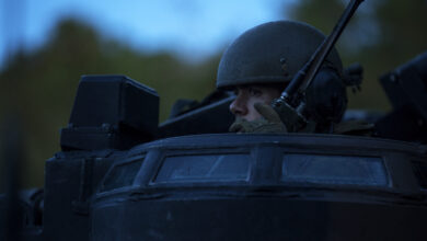 A marine communicates over a radio in an amphibious assault vehicle.