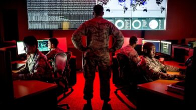 A cyber warfare operations officer watches members of the 175th Cyberspace Operations Group analyze log files and provide a cyber threat update.