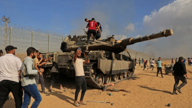 Palestinian terrorists take control of an Israeli tank after crossing the border fence with Israel from Khan Younis in the southern Gaza Strip on October 7, 2023
