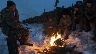 Crew members of a Ukrainian BMP-2 armored vehicle warm themselves by a fire before returning to the firing line for a night fire exercise at the International Peacekeeping and Security Center, near Yavoriv, Ukraine, on Feb. 16. (Photo by Sgt. Anthony Jones, 45th Infantry Brigade Combat Team)