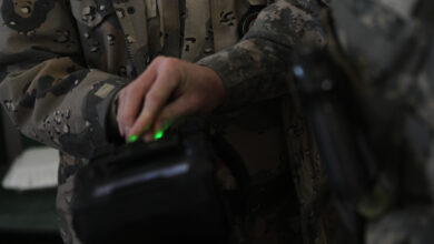 An Army soldier demonstrates a biometrics device during Vice Adm. Robert S. Harward's visit to Zaranj, Afghanistan, Jan 6. The commanding officer of Combined Joint Interagency Task Force 435 toured a provincial prison and the Iran/Afghanistan border crossing.