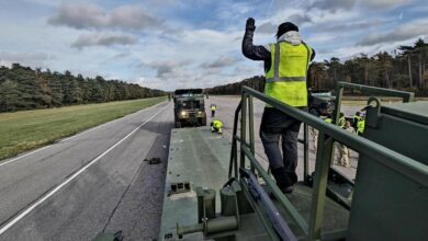 A Belgian host nation employee from Army Field Support Battalion-Benelux, 405th Army Field Support Brigade, ground guides an M1300 Enhanced Heavy Equipment Transporter onto an M1302 trailer at the Zutendaal Army Prepositioned Stocks-2 worksite in Belgium during an EHET drivers academy held there NOV. 6-22. (U.S. Army courtesy photo)