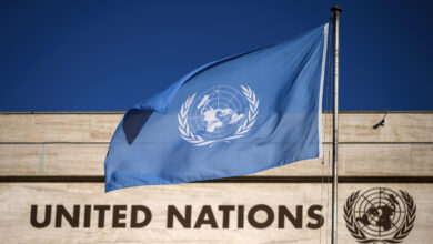 A flag flutters in wind at the main entrance of the building which houses the United Nations Offices in Geneva
