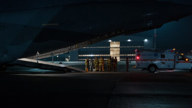 Firefighters from the 86th Civil Engineer Squadron Kaiserslautern Military Community Fire Emergency Services stand by after transporting a wounded warrior from a C-17 Globemaster III to an ambulance on Aug. 9, 2015, on Ramstein Air Base, Germany. Ramstein fire and medical personnel from the 10th Aeromedical Evacuation Operations Team and the 455th Critical Care Air Transport Team assisted with the aeromedical evacuation out of Afghanistan. (U.S. Air Force photo/Staff Sgt. Leslie Keopka)