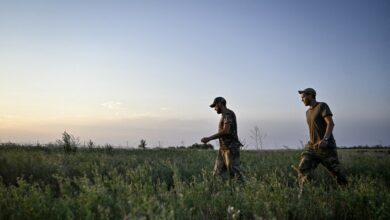 Ukraine's Servicemen of the 24th King Danylo Separate Mechanized Brigade are walking through a field during a combat mission near Chasiv Yar