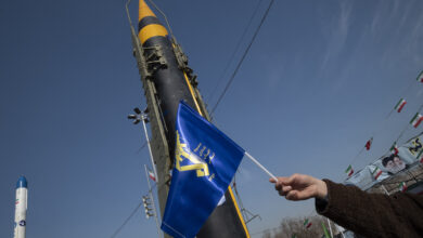 A man is waving a flag of the Islamic Revolutionary Guard Corps (IRGC) in front of the Iranian-made Kheibar Surface-to-Surface missile at Azadi (Freedom) Square in western Tehran, Iran, on February 11, 2024, during a rally to mark the 45th anniversary of the victory of Iran's 1979 Islamic Revolution. The Iranian Islamic Revolution, which led to the overthrow of the Pahlavi dynasty in 1979, replaced the Imperial State of Iran with the present-day Islamic Republic of Iran. (Photo by Morteza Nikoubazl/NurPhoto) (Photo by Morteza Nikoubazl / NurPhoto / NurPhoto via AFP)