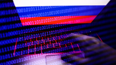 Russian flag displayed on a laptop screen and binary code code displayed on a screen are seen in this multiple exposure illustration photo taken in Krakow, Poland on February 16, 2022. (Photo illustration by Jakub Porzycki/NurPhoto) (Photo by Jakub Porzycki / NurPhoto / NurPhoto via AFP)