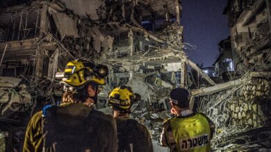 Rescue workers inspect the remains of a building hit by an Iranian missile in Tel Aviv, Israel, on June 13, 2025
