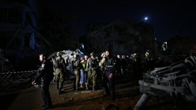 Israeli first responders arrive at a site hit by a missile fired from Iran in central Israel