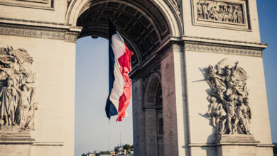 A French flag under the Arc de Triomphe during the preparation of the annual Bastille Day military parade on the Champs Elysees avenue in Paris France on July 14, 2025. (Photo by Bastien Ohier / Hans Lucas via AFP)