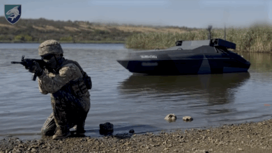A soldier positioned in front of a docked Barracuda.
