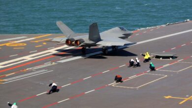 A J-35 fighter jet taking off from the Fujian aircraft carrier while staff are crouched