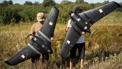Two people show off the new kamikaze drones developed by Brave1 for Ukraine forces