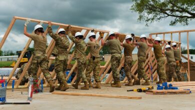 Airmen from all trades, with the 176th Wing’s Civil Engineer Squadron, raise the second exterior wall in unison as they construct the first home in the Cherokee Veterans Housing Initiative in Tahlequah, Oklahoma, May 18, 2021. The initiative is a collaboration between the Department of Defense’s Innovative Readiness Training program and the Cherokee Nation that constructs new single-family homes and supporting infrastructure for eligible Cherokee Nation veterans and their families. (U.S. Air Guard photo by Staff Sgt. Clay Cook)