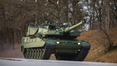 Leopard 2A8 main battle tank driving on a road during field testing, showing its upgraded armor, modern turret design, and advanced defensive systems