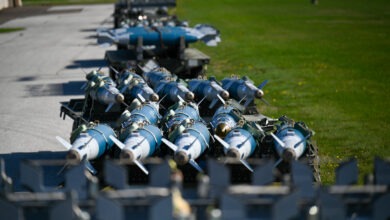 Inert GBU-38 bombs sit on a palate ready to be loaded onto an F-16 Fighting Falcon