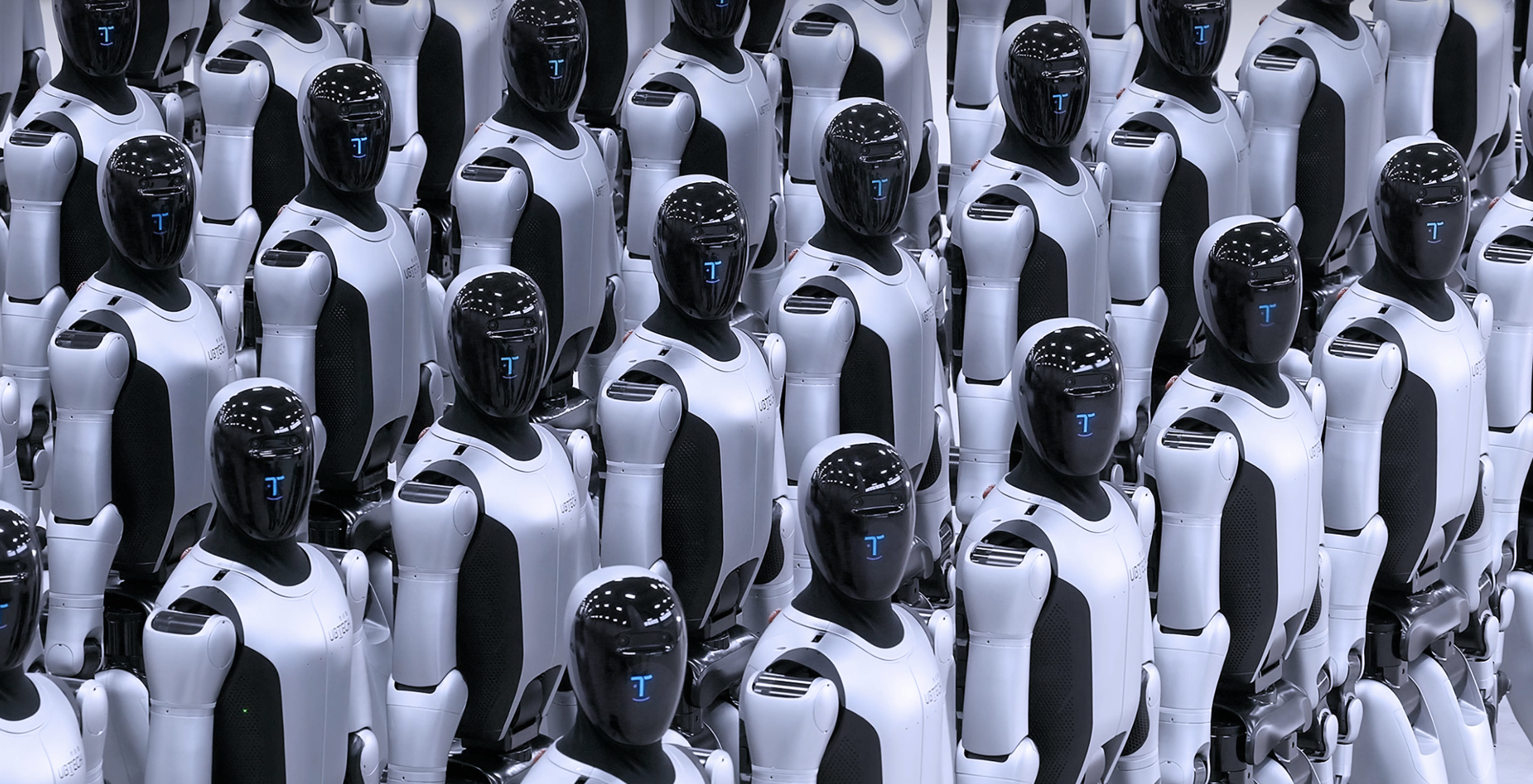Rows of humanoid combat robots stand in formation, featuring white armored bodies and black visors with blue digital displays, resembling a mass-produced autonomous fleet