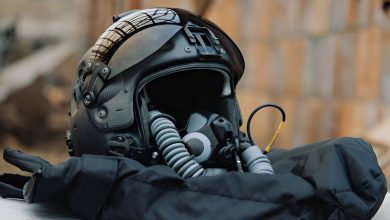 Gentex PURSUIT flight helmet for the US Navy, shown with integrated oxygen mask, visor, and communications gear resting on a padded surface during a press display.