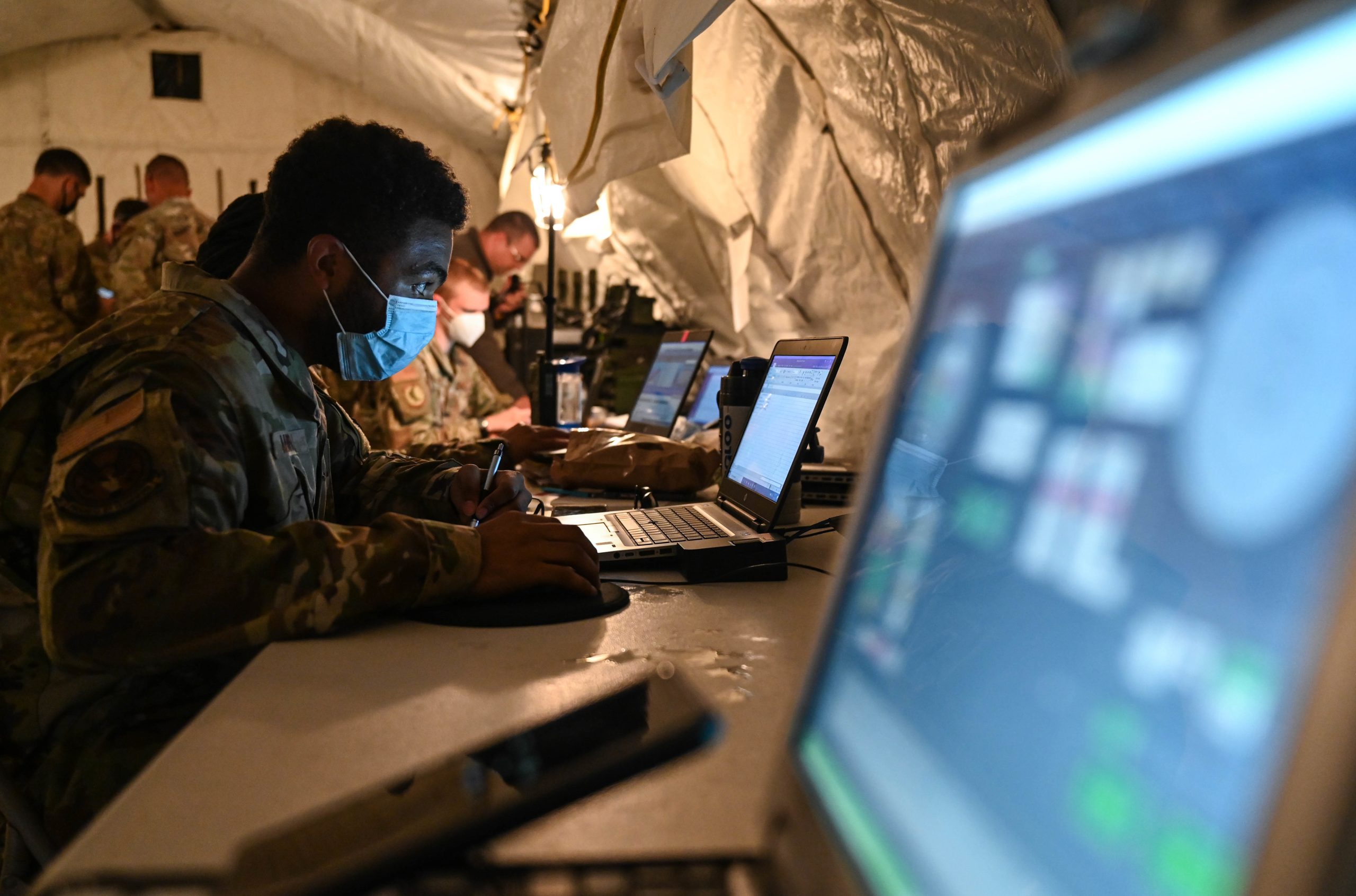 U.S. Air Force members of the utilize computer communication systems during the Agile Flag 21-2 experiment at Naval Outlying Landing Field Choctaw, Florida, May 3, 2021. Air Combat Command developed the Agile Flag 21-2 experiment to create a lead wing, aligning squadrons from different locations under a single commander, enhancing their readiness as a team before deploying into a contested environment. (U.S. Air Force photo by Senior Airman Sarah Dowe)