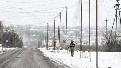 A soldier armed with a rifle stands on the roadside under an anti-drone net covering the road to protect from Russian FPV drone strikes in the Donetsk region, Ukraine, on January 23, 2026.