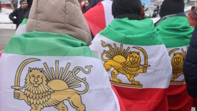 Protesters drape themselves in Iranian flags as 350,000 Canadians take part in a protest against the Islamic Republic of Iran in Toronto, Ontario, Canada, on February 14, 2026.