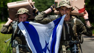 Israel Defense Forces Sgt. Yuval Chen and Sgt. Daniel Yastrijemski, visual information specialists assigned to Israel Defense Forces Combat Camera Unit, participate in "The Hunter," a culminating event that includes a two mile run, a three mile ruck, and a one mile water jug carry while competing in the 2022 Spc. Hilda I. Clayton Best Combat Camera Competition at Fort A.P. Hill, Virginia, May 22, 2022. The annual multi-day competition tests the tactical and technical proficiency of visual information and public affairs specialists across the DOD and participating international competitors. (U.S. Army photo by Spc. Rhianna Ballenger)