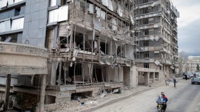 An Iranian motorcyclist rides past the Gandhi Hospital, which is damaged after US-Israeli strikes on a state TV telecommunication tower nearby in Tehran, Iran, on March 2, 2026.