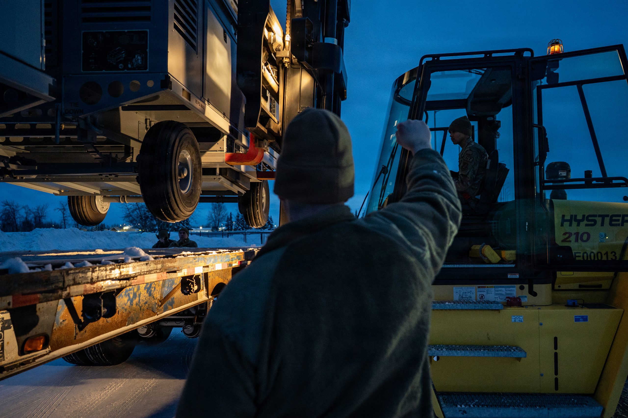 U.S. Air Force Senior Airman Jakob Smith, 773d Logistics Readiness Squadron ground transportation support operator, guides a forklift during a Prepositioned Warfighting Materiel movement at Joint Base Elmendorf-Richardson, Alaska, Jan. 15, 2026. The movement of PWM revamps Pacific Air Command's ability to rapidly generate airpower and provides the theater with enhanced infrastructure, robust material maintenance, and advanced command, control, communications, computers, and intelligence capabilities. (U.S. Air Force photo by Senior Airman Hunter Hites)