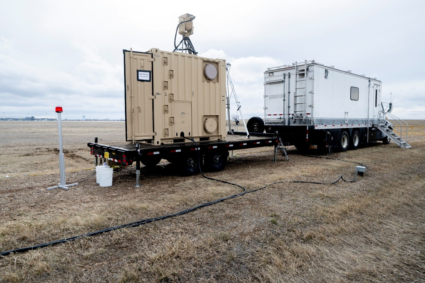 US Naval Research Laboratory mobile laser system on flatbed trailer deployed in field, used for power beaming and counter-UAS operations