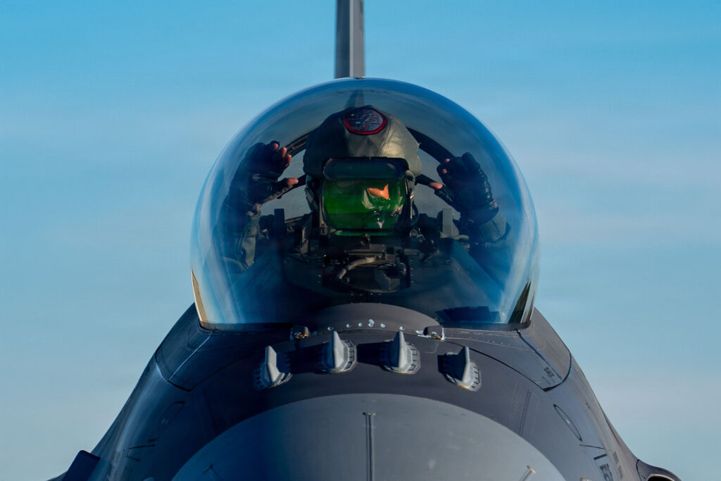 Col. Brandon Eskam, commander of the 114th Fighter Wing, South Dakota Air National Guard, gestures from the cockpit of an F-16 Fighting Falcon