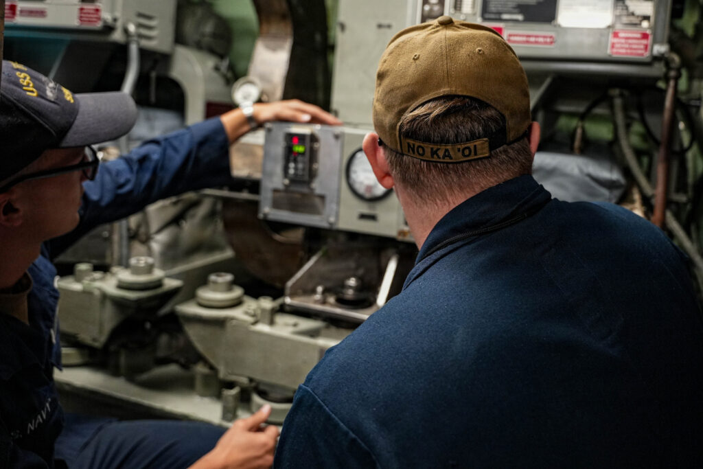Machinist’s Mate (Auxiliary) 2nd Class James Wofford, assigned to Pearl Harbor Naval Shipyard and Intermediate Maintenance Facility, right, and Machinist’s Mate (Auxiliary) 2nd Class Logan Kaiser, assigned to Los Angeles-class fast-attack submarine USS Toledo (SSN 769), monitor gauge readings aboard Toledo at Joint Base Pearl Harbor-Hickam, Hawaii, Sept. 18, 2025.