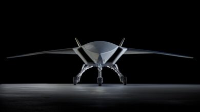 Boeing MQ-28 Ghost Bat autonomous combat drone front view on hangar floor, showing low-observable flying wing design and tricycle landing gear