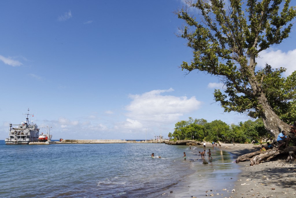 The port, a ship, and inhabitants on the beach of Lenakel, the main city on the island of Tanna in the south of the Vanuatu archipelago