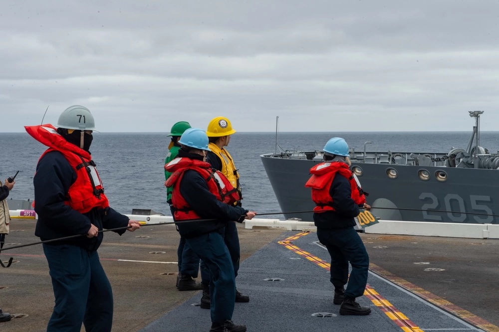 Sailors aboard USS Theodore Roosevelt conduct a replenishment-at-sea with the fleet replenishment oiler USNS John Lewis in the Pacific Ocean.