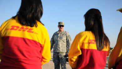 U.S. Army Lt. Col. John Motley, resource manager, assigned to United States Forces - Iraq, J33 Information Operations speaks with DHL workers in Victory Base, Baghdad, Iraq, Nov. 20. DHL workers delivered sporting goods to Kashafa, Iraqi Boy and Girl Scouts.