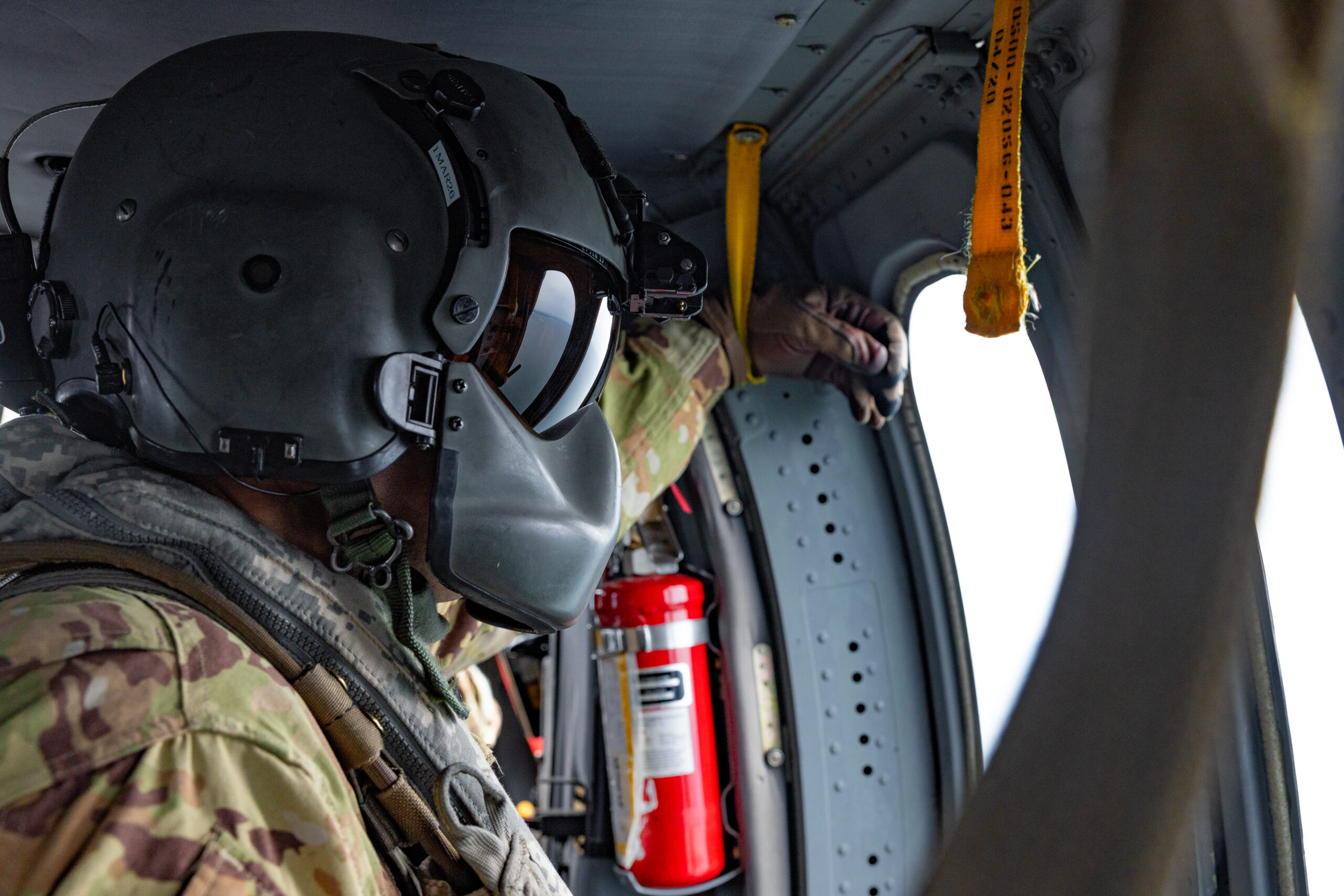 Connecticut Army National Guard Sgt. 1st Class Richard Wooten, a crew chief assigned to 1109th Theater Aviation Support Maintenance Group, looks out the window of a UH-60 Blackhawk helicopter, during a flight over the United States, Sept. 8, 2025. Wooten wears the HGU-56/P Aircrew Integrated Helmet System, which offers improved comfort, impact protection, retention and sound attenuation over the SPH-4 flight helmet which it replaced. (U.S. Army photo by Sgt. Matthew Lucibello)