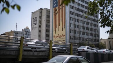 Vehicles move along an avenue beneath an anti-US mural in Tehran, Iran, on July 16, 2026.
